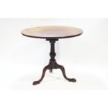 A George III style mahogany tripod table, with bird cage top to pedestal base,