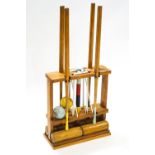 A design centre croquet set with four mallets, six hoops, finishing post and two balls, on stand,
