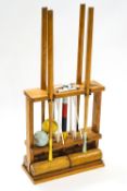 A design centre croquet set with four mallets, six hoops, finishing post and two balls, on stand,