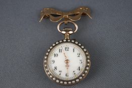 A open face fob watch with blue enamel finish and seed pearls fixed to a 9ct gold bow brooch.