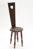 An oak Welsh spinning chair with chip carved decorated back over an octagonal seat,