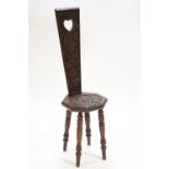 An oak Welsh spinning chair with chip carved decorated back over an octagonal seat,