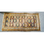 A small tribal rug with three rows of medallions within two borders,