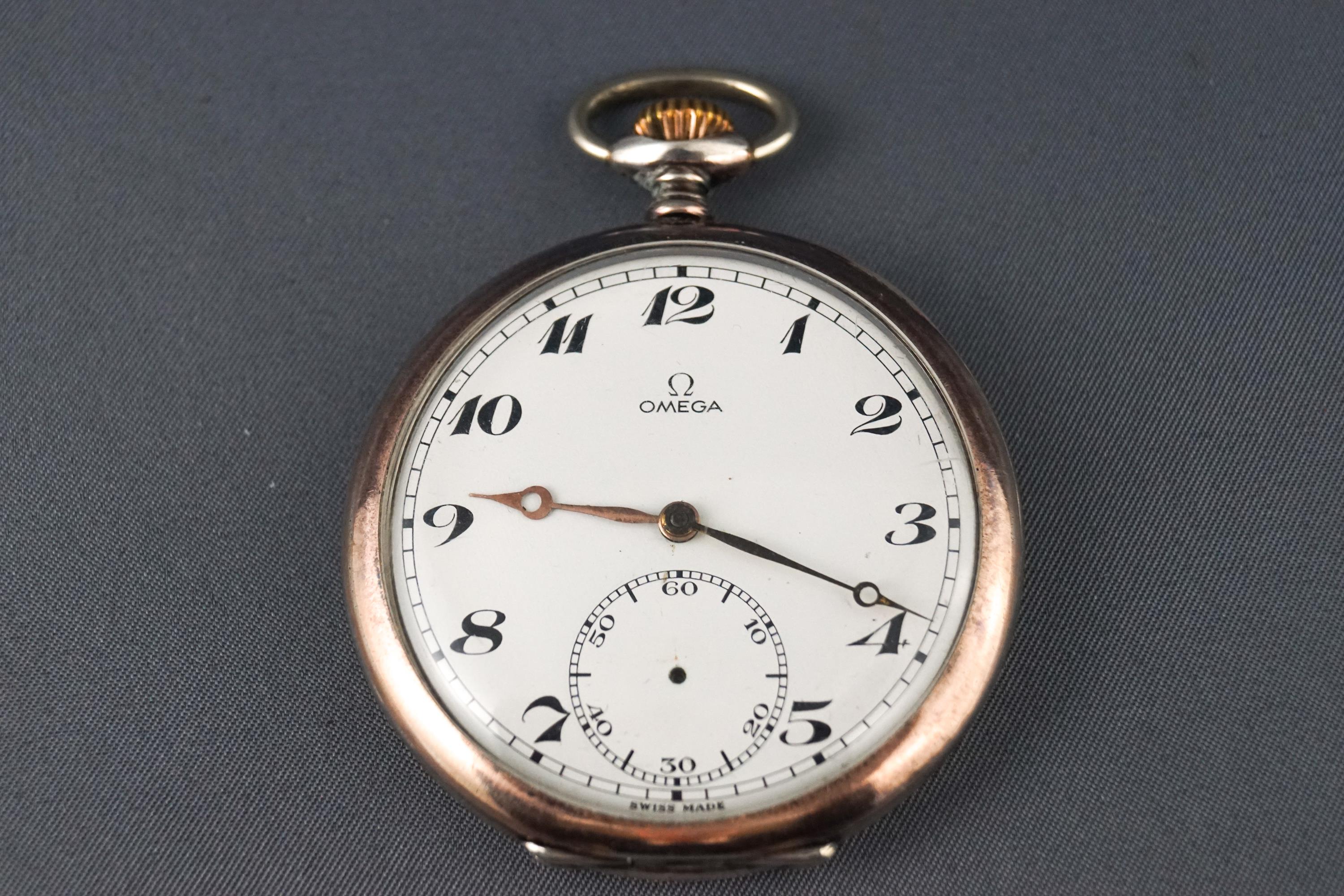 A stainless steel open face pocket watch, signed Omega with white ceramic dial and gilt hands.