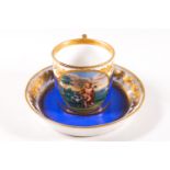 A Vienna cabinet cup and saucer, painted with putti within a gilt roundel on a blue ground,