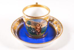 A Vienna cabinet cup and saucer, painted with putti within a gilt roundel on a blue ground,