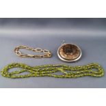 A Victorian mosaic fossil brooch, a peridot nugget necklace and a yellow metal bracelet