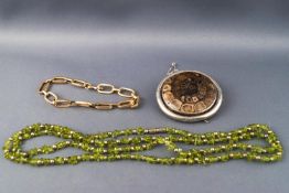 A Victorian mosaic fossil brooch, a peridot nugget necklace and a yellow metal bracelet