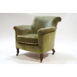 An Edwardian green velvet upholstered tub shaped armchair with scroll back on arms
