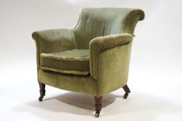 An Edwardian green velvet upholstered tub shaped armchair with scroll back on arms