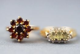 A collection of rings to include a green quartz and diamond cluster ring and a garnet cluster ring.