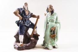 Two Chinese Shiwan (mud man) figures, one standing on a rocky base with an axe,