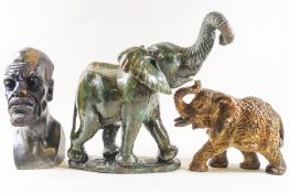 A green carved stone figure of an elephant, 25cm high, and a carved stone bust of an African man,