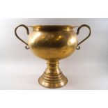 A large scale brass two handled urn with flared foot.
