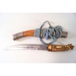 A Balinese knife with carved bone handle, and white metal mounted scabbard,