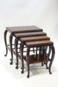 A nest of four 1930's Asian hardwood tables with acanthus carved shoulders on claw and ball feet,