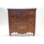A mahogany bow front chest of two short and three long drawers over a shaped apron on baluster