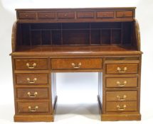 A contemporary mahogany bureau with six small drawers over a tambour top....