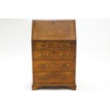 A Georgian oak bureau with fall front over lopers and four drawers with brass swan neck handles