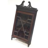 An Edwardian mahogany corner cabinet, with broken swan neck pediment,