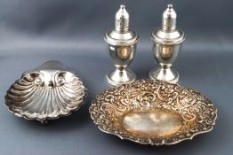 An oval silver pint tray/sweet meat dish, a shell shaped butter dish and a pair of baluster peppers