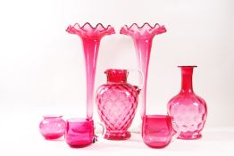 A pair of Victorian cranberry glass trumpet vases, each with clear glass flared feet, 31cm high,