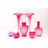 A pair of Victorian cranberry glass trumpet vases, each with clear glass flared feet, 31cm high,