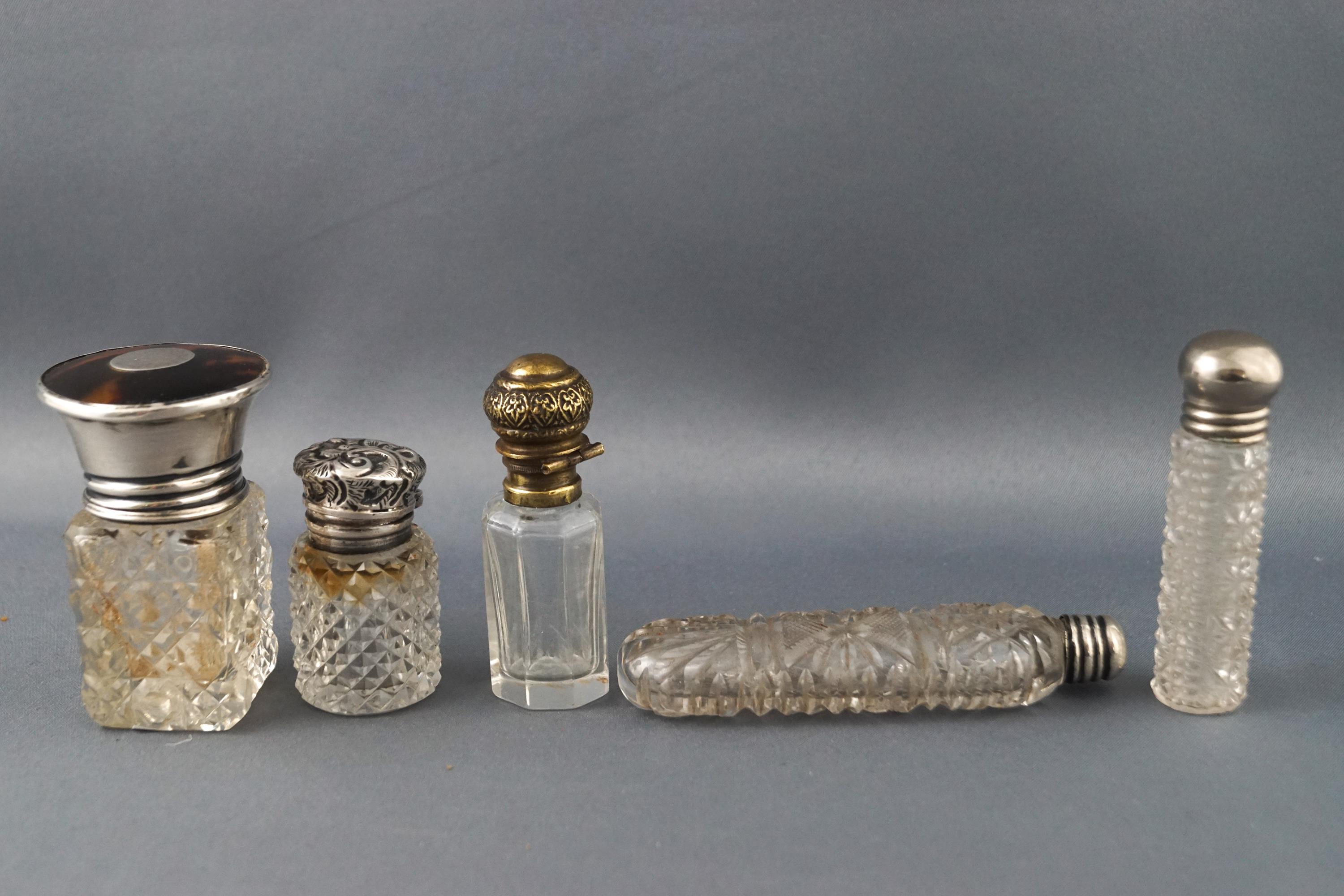 A cut glass scent bottle with a silver and tortoiseshell lid,