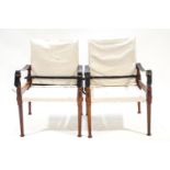 A pair of teak campaign chairs with canvas backs and seats,