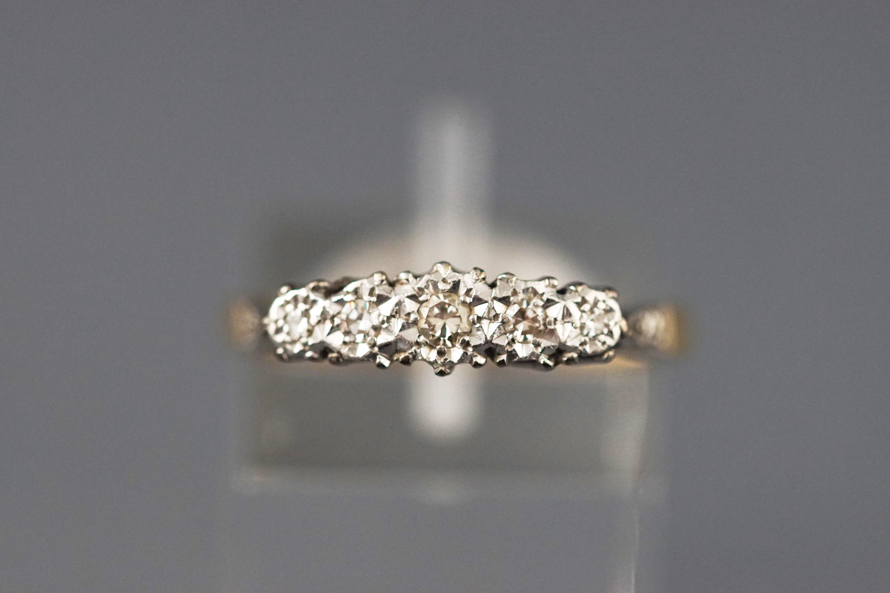 A yellow and white metal five stone diamond ring. Set with five graduated single cut diamonds.