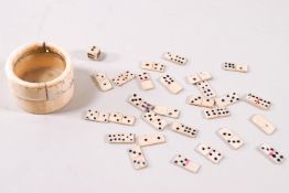 A 19th century carved bone cylindrical box and cover containing miniature bone dominoes and dice