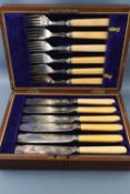 A mahogany cased set of electroplated fish knives and forks with bone handles and silver collars,