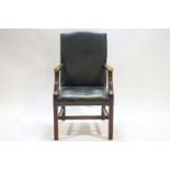 A George III style leather upholstered elbow chair with mahogany arm supports and square legs