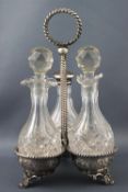 A silver trefoil cruet frame on three feet, suspended from a twisted rope work ringed finial handle,