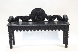 A Victorian ebonised oak window seat with carved shaped back and legs,