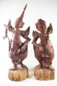 A pair of carved Balinese figures of dancers, in traditional costume, 65cm high,