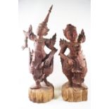 A pair of carved Balinese figures of dancers, in traditional costume, 65cm high,