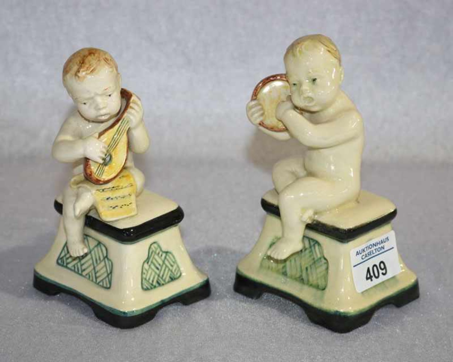 2 Keramikfiguren 'Musizierende Puttos', farbig glasiert, H 14 cm, B 9 cm, T 7 cm, Altersspuren