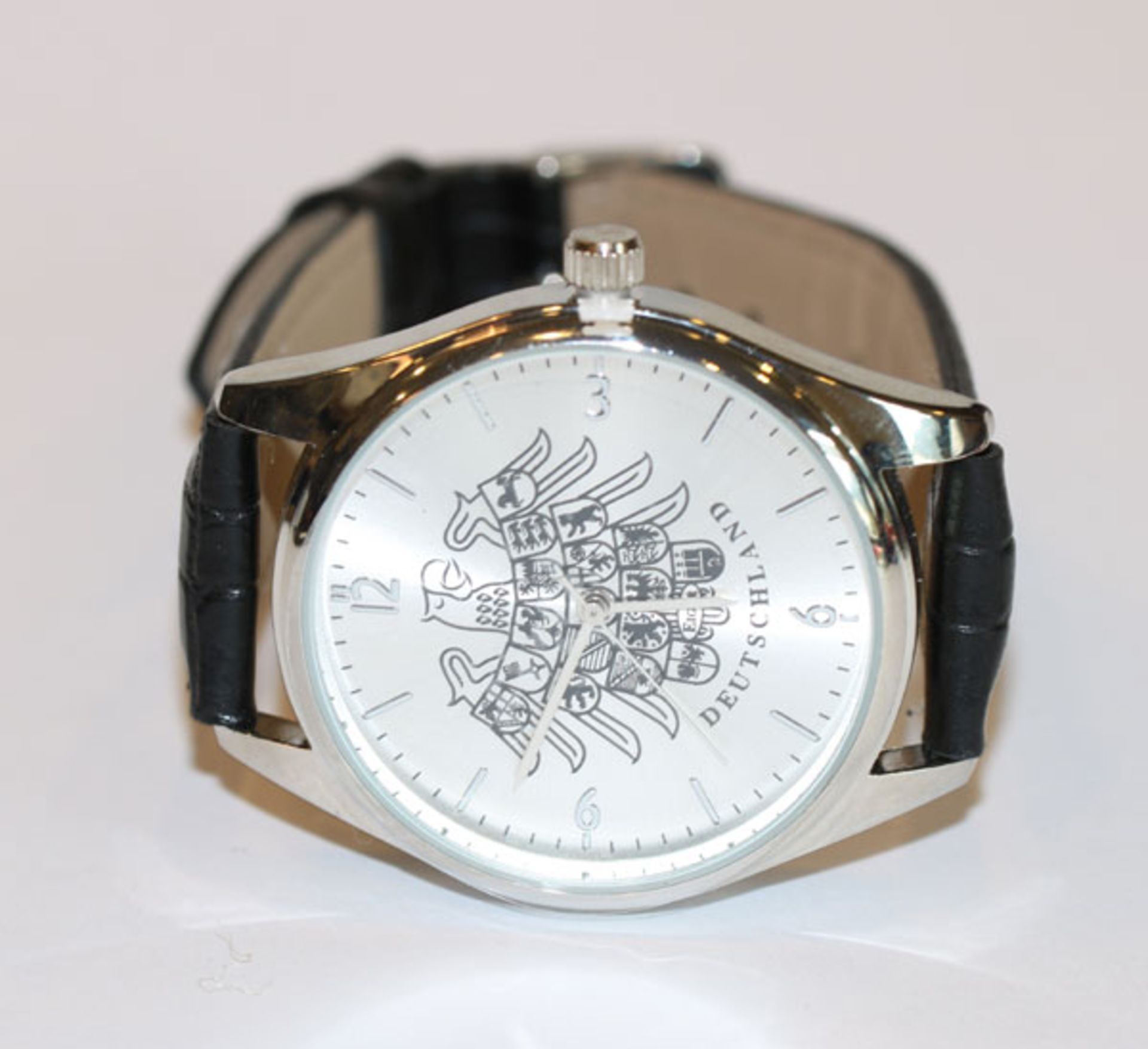 Herren Armbanduhr, Zifferblatt mit deutschem Adler und Länderwappendekor, an schwarzem Armband,