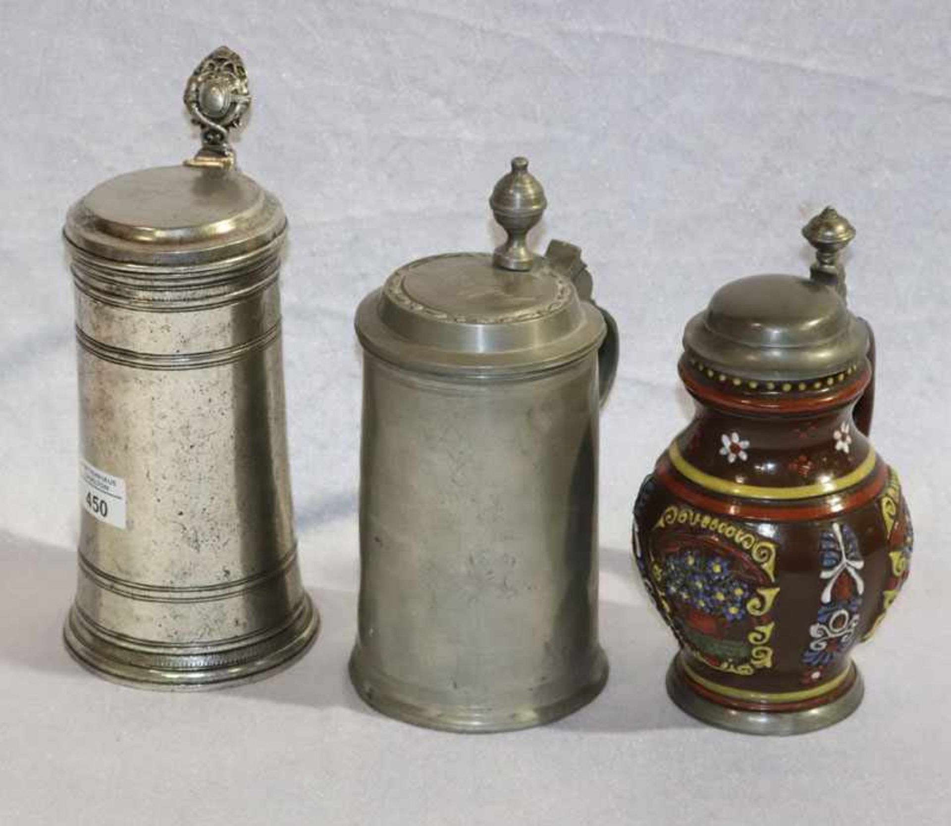 2 Zinn Krüge mit Deckel, H 24/26 cm, und Keramik Henkelkrug mit Reliefdekor, farbig bemalt, Zinn-
