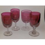 A cranberry wine glass with hollow faceted stem and three others. (4)