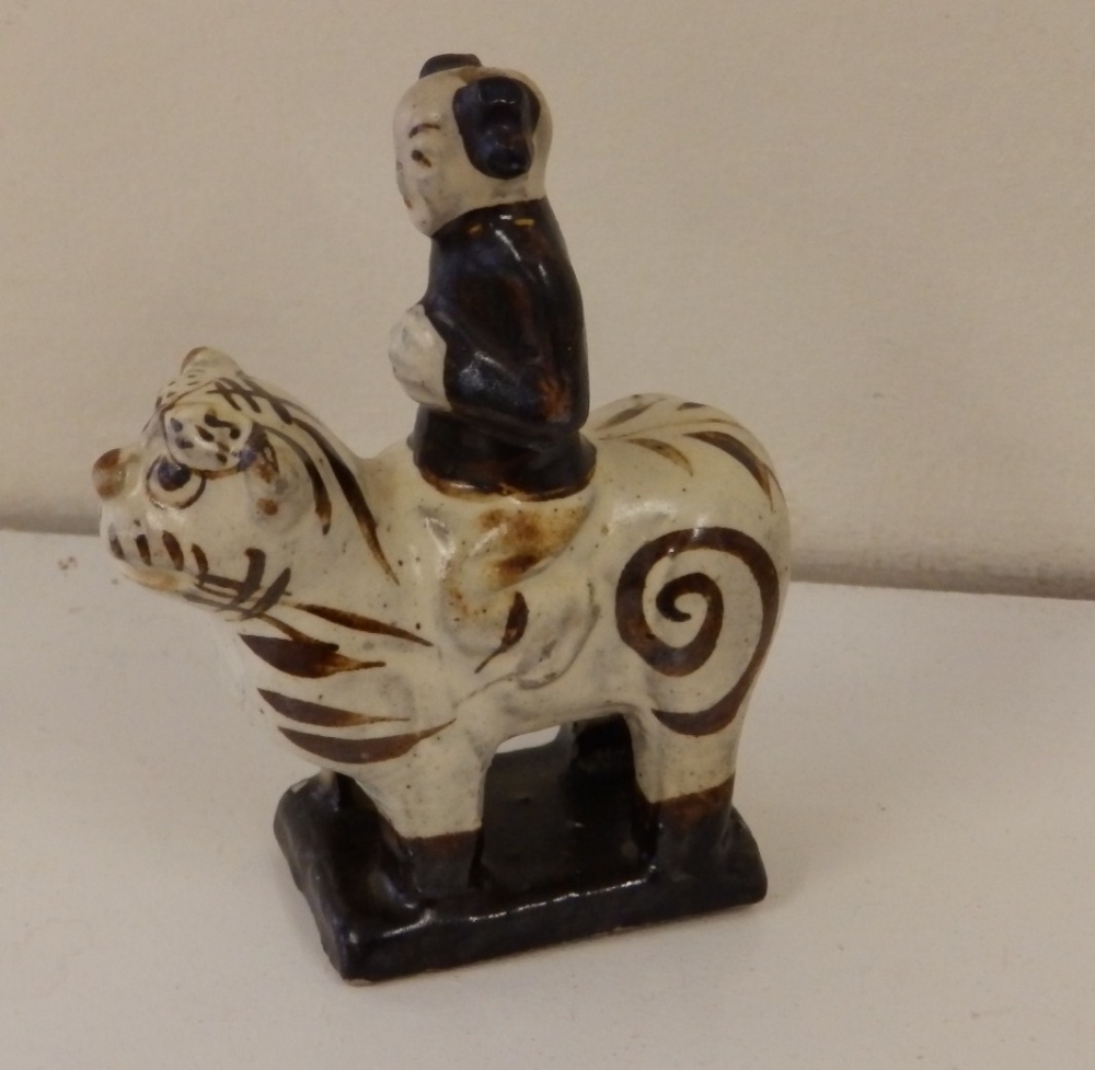 A small Chinese stoneware model of a lohan riding a tiger, Northern Song Dynasty (960-1127AD),