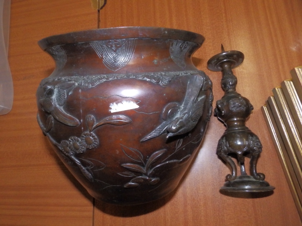 An Oriental bronzed jardiniere (holed) and a pricket candlestick. (2)