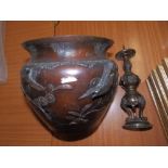 An Oriental bronzed jardiniere (holed) and a pricket candlestick. (2)