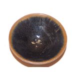 A small Chinese Song Dynasty stoneware bowl, glazed in black with brown rim, 3.5” diameter.