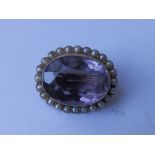 An oval amethyst & pearl brooch – 'JGG 9ct', 1” across.