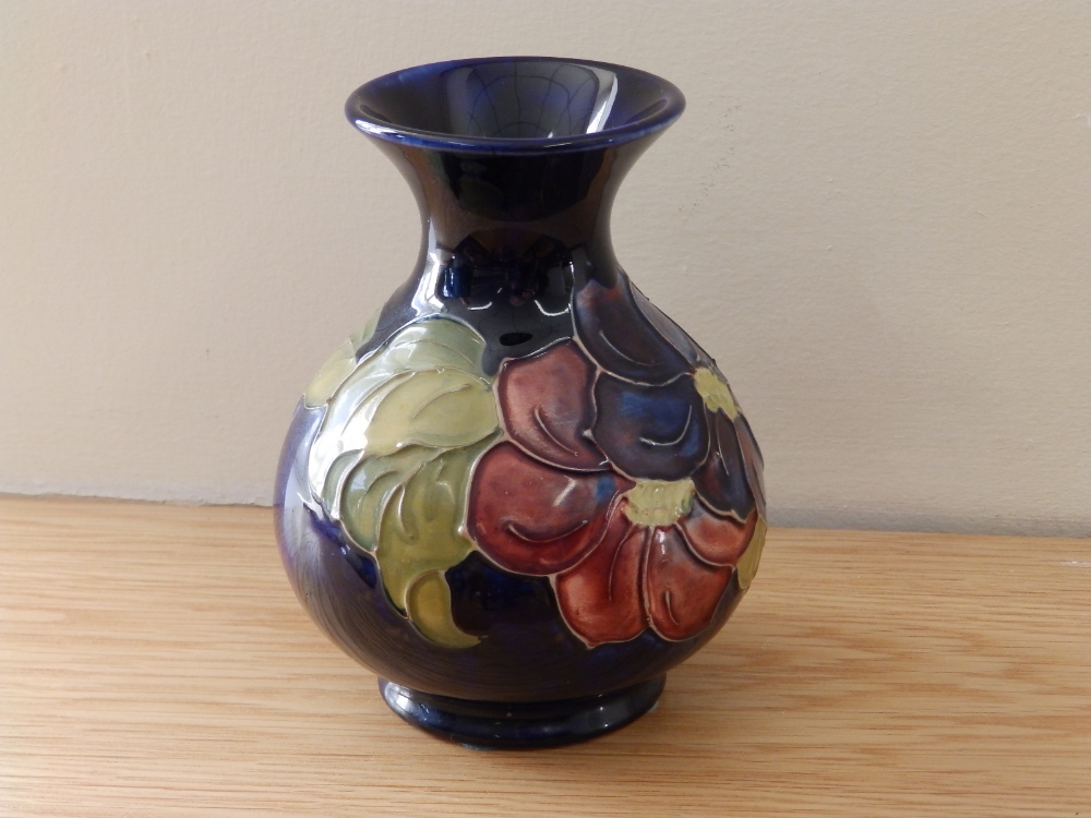 A Walter Moorcroft Clematis pattern dark blue vase.