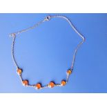 A carnelian necklace set with six cabochon stones.