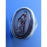 A Classical style oval signet ring set with an intaglio carved with standing female and Greek