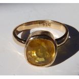 An oval cut yellow sapphire solitaire ring in yellow metal – the sapphire weighing approximately 3.8